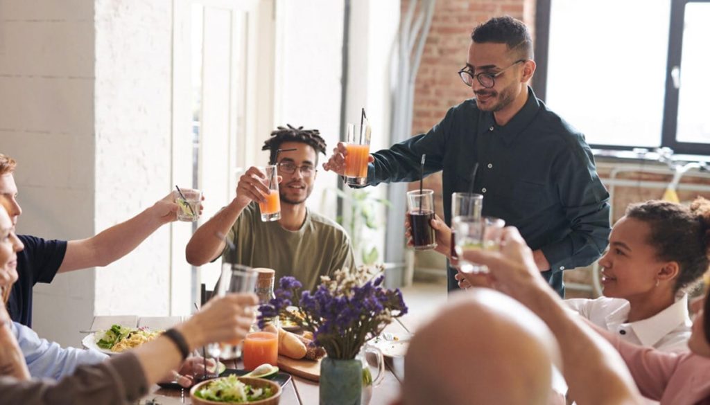 A family around a holiday table toasting drinks