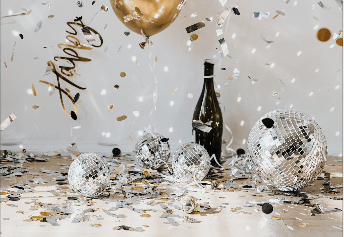 Celebration decorations with confetti, disco balls and gold balloons