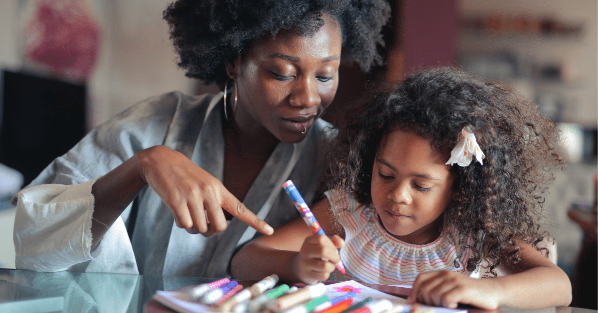 mom helping girl with coloring