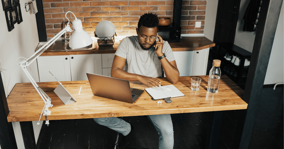 man sitting at home desk with laptop