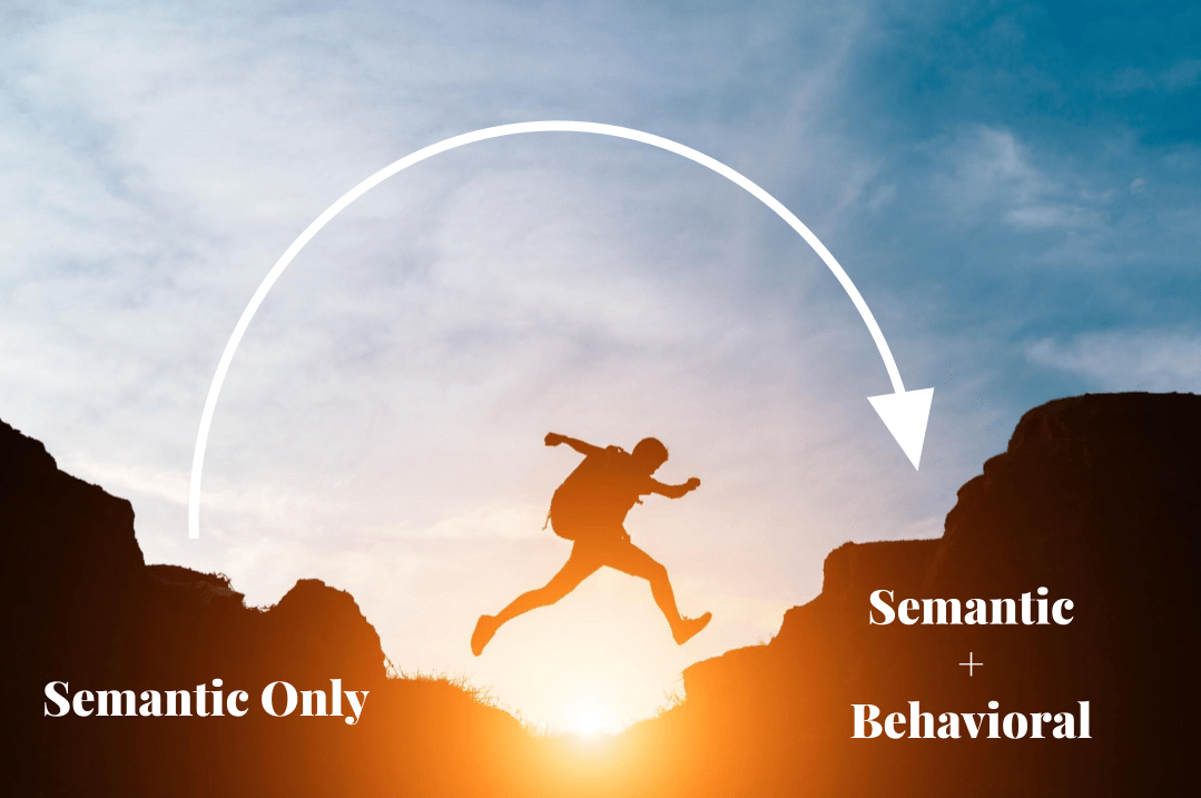 An outline of a person leaping from one rock formation to another against a setting sun