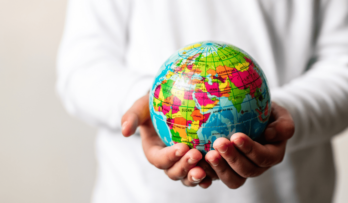 hands holding a colorful globe