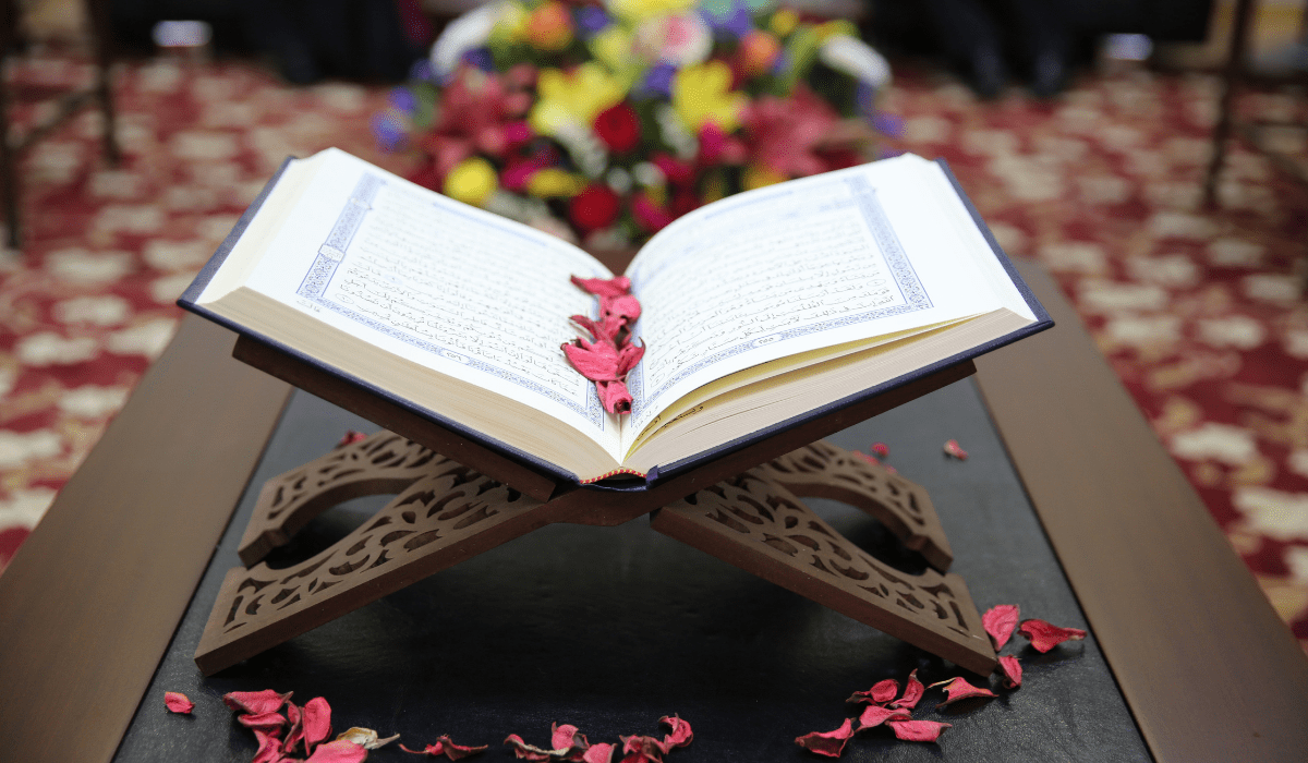 open holy book on a stand surrounded by flower petals