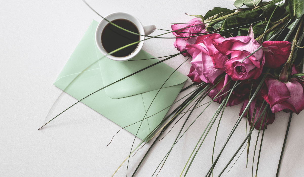 top down view of card, coffee, and roses
