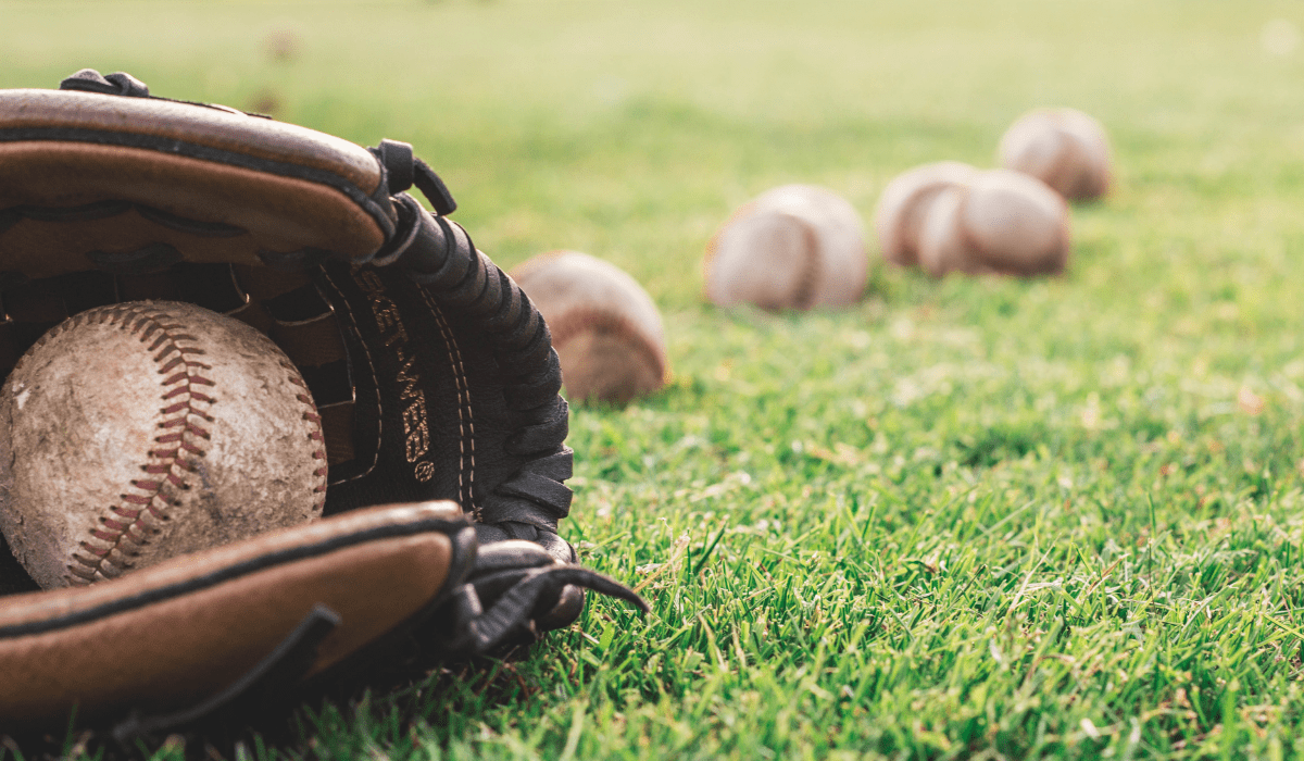 closeup view of a mitt and baseballs on the grass
