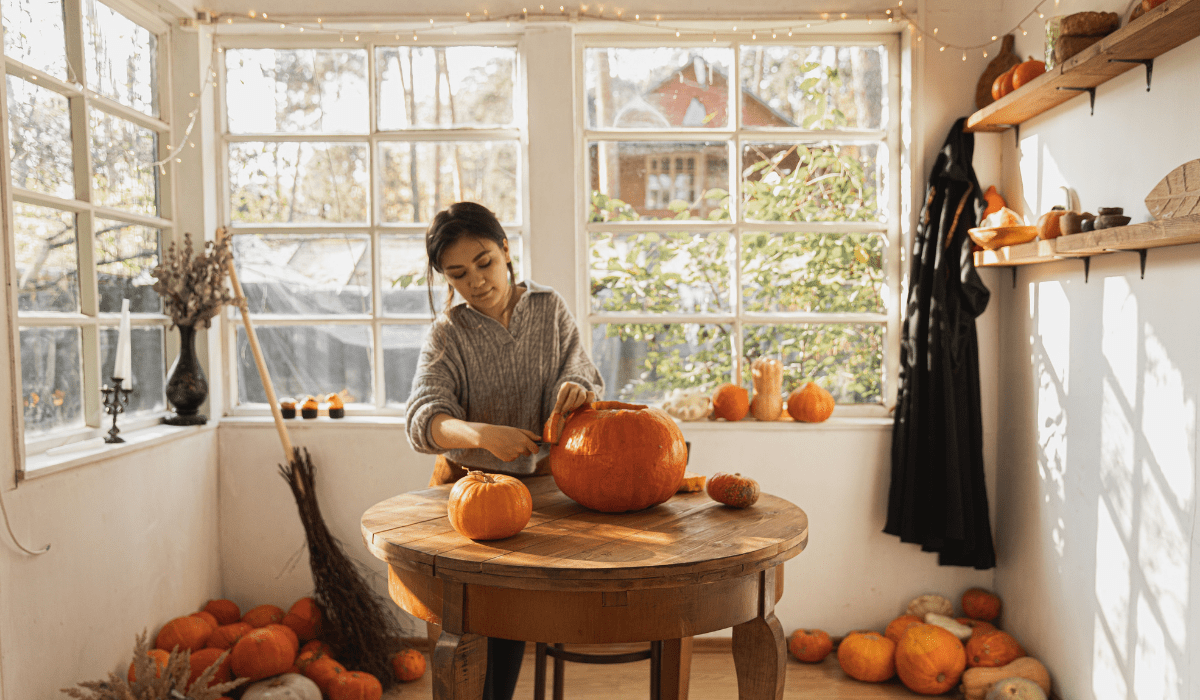 woman in kitchen carving pumpkins