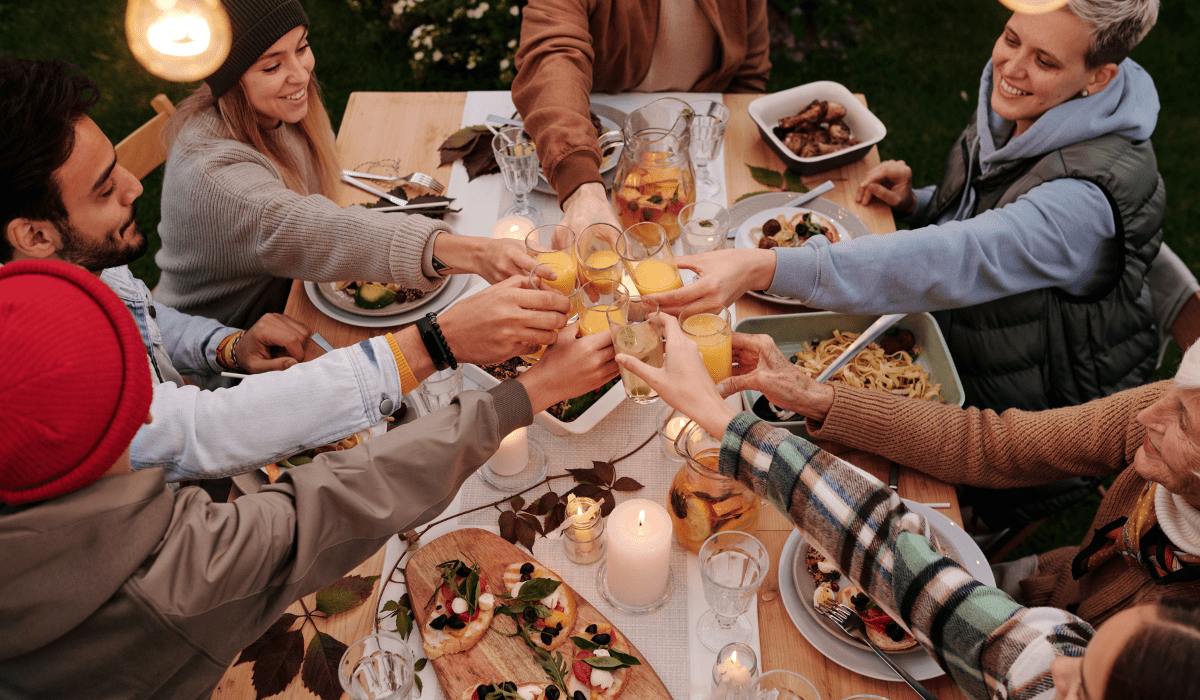 people toasting around a table with food