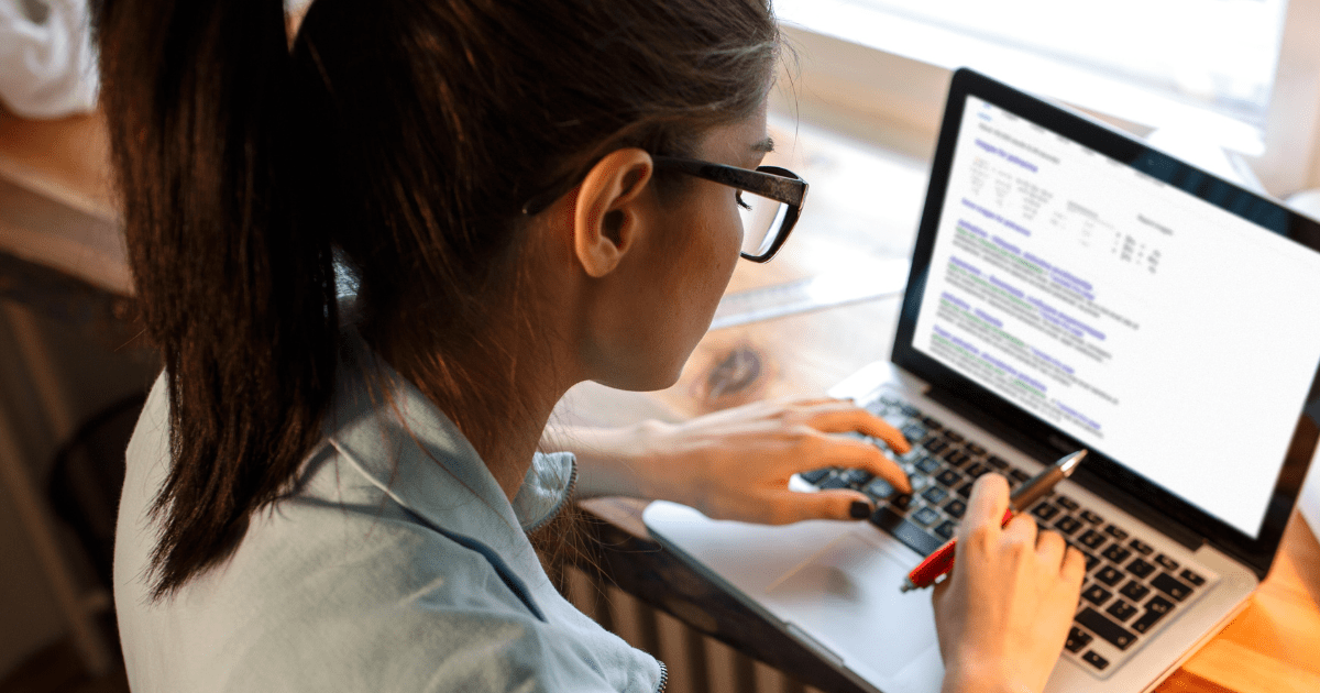 A person sitting at a desk typing on a laptop