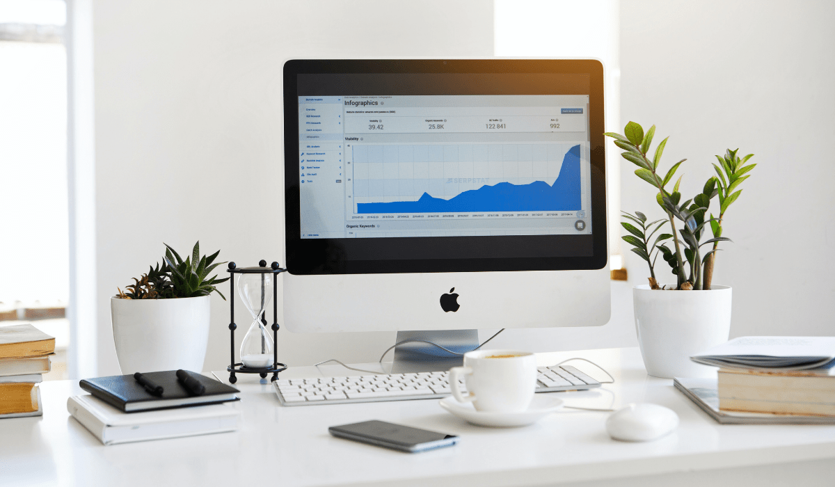 Desk with a computer showing a graph, plants, and coffee