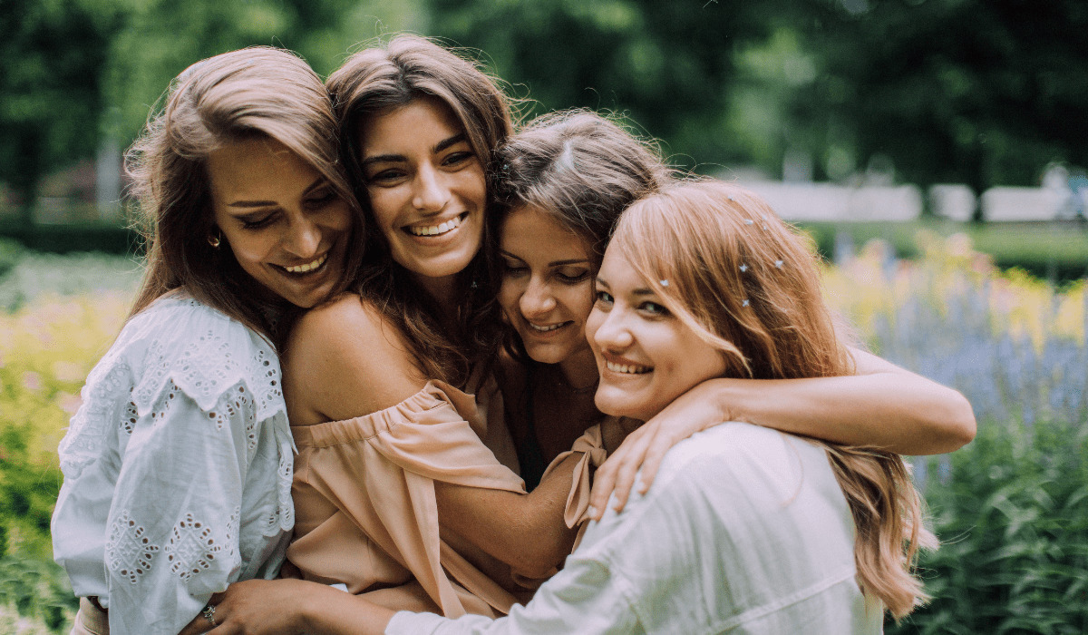 Four women hugging and smiling
