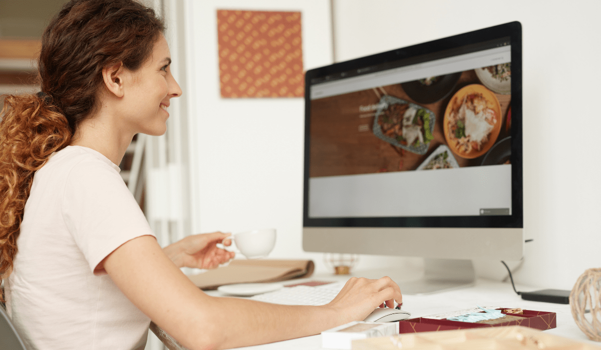 A person sitting looking at a desktop screen smiling